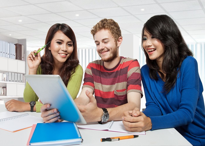 Group of diversity happy students studying together using tablet pc